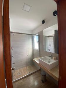 La salle de bains est pourvue d'un lavabo blanc et d'une douche. dans l'établissement Fincas del Real, à Colonia del Sacramento