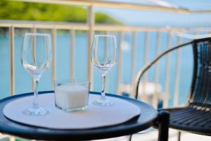 two wine glasses sitting on a table on a balcony at Apartment Niksa in Novigrad Dalmatia