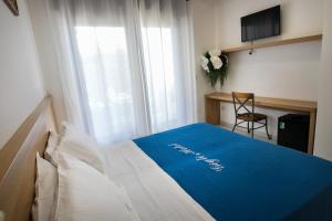 um quarto com uma cama com um cobertor azul em Gigli Hotel Salento em Marina di Pescoluse