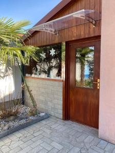 a wooden front door of a house with a palm tree at Casa Sheila in Quartino