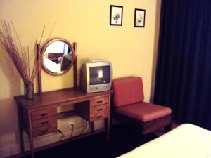 a bedroom with a desk with a tv and a chair at Residencial do Mar in Praia de Mira