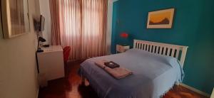 a small bedroom with a bed with blue walls at Sonia's Homestay in Rio de Janeiro