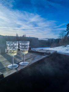 dos copas de vino sentadas en una mesa en una terraza en Koniakowo - dom Forest, en Koniaków