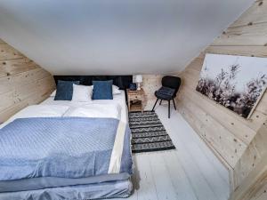 a bedroom with a bed and a chair in a attic at Koniakowo - dom Forest in Koniaków