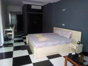 1 dormitorio con 1 cama y suelo blanco y negro a cuadros en Mosaly Hotel PK10, en Porto Novo