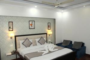 a bedroom with a large bed and two chairs at Krishna Residency - A Boutique Hotel in Bareilly