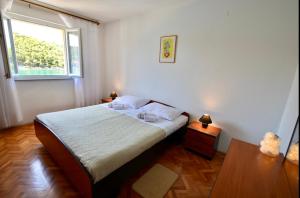 a bedroom with a large bed and a window at Apartment Niksa in Novigrad Dalmatia