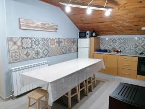 a kitchen with a large white table in a room at Casas do Patrao II in Sabugueiro