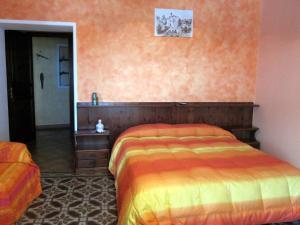 a bedroom with a bed and an orange wall at agriturismo u zu peppino in Lipari