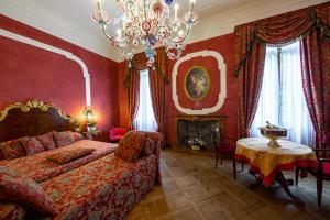 una camera con letto, tavolo e lampadario a braccio di Hotel San Moisè a Venezia