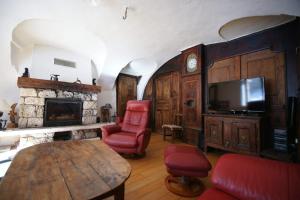 a living room with a fireplace and a tv at Room for two in a house of the XVII century - N2 Chez Jean Pierre in Villar-dʼArène