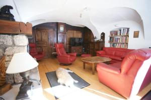 a living room with a red couch and red chairs at Room for two in a house of the XVII century - N2 Chez Jean Pierre in Villar-dʼArène