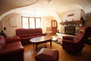 a living room with leather furniture and a fireplace at Room for two in a house of the XVII century - N2 Chez Jean Pierre in Villar-dʼArène