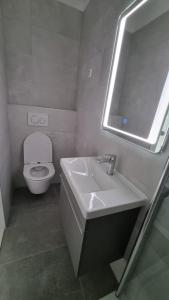 uma casa de banho com um lavatório, um WC e um espelho. em Room Airport Split em Kaštela