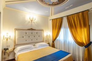 a bedroom with a large bed with yellow curtains at Hotel Porta Faenza in Florence