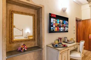 a mirror on a wall next to a vanity with a table at Hotel Porta Faenza in Florence