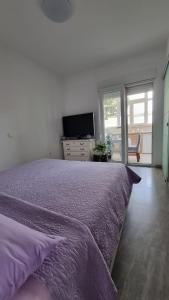 um quarto com uma cama com um cobertor roxo em Room Airport Split em Kaštela