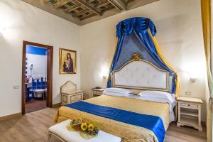 a bedroom with a king sized bed with a blue canopy at Hotel Porta Faenza in Florence