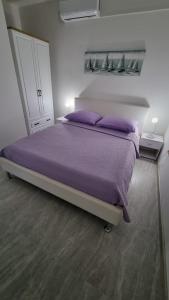 a bedroom with a large bed with purple pillows at Room Airport Split in Kaštela