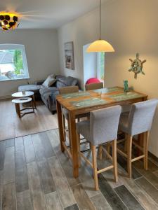 a dining room and living room with a table and chairs at Doddy‘s Stuuv in Niesgrau