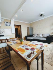 ein Wohnzimmer mit einem Tisch und einem Sofa in der Unterkunft Уютная квартира с панорамой города in Odessa