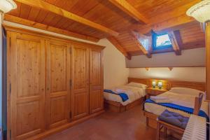 a bedroom with two beds and a wooden ceiling at CHALET PONTAL 5 - Relax e vista sulle montagne - COUR 0145 in Entrèves