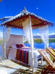 a bed in a gazebo with a view of the water at Titicaca wasy lodge in Puno