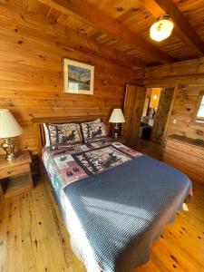 a bedroom with a bed in a log cabin at Unity Sky Lodge in Jackman