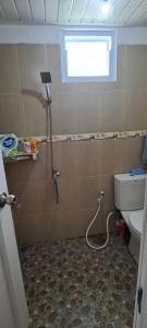 La salle de bains est pourvue d'une douche et de toilettes. dans l'établissement Bandar Lampung Villa, à Kedaton