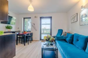 a living room with a blue couch and a table at Apartamenty Pod Dębem in Wicie +20 photos