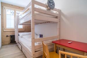 een stapelbed in een kamer met een rode tafel bij Apartment Ahornisegg - GRIWA RENT AG in Grindelwald