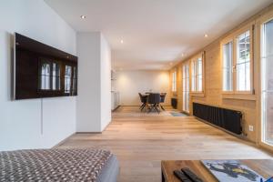 een slaapkamer met een bed en een tafel en ramen bij Apartment Ahornisegg - GRIWA RENT AG in Grindelwald