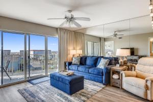 a living room with a blue couch and a large window at Seacrest 610 is a 2 BR Gulfside on Okaloosa Island condo in Fort Walton Beach