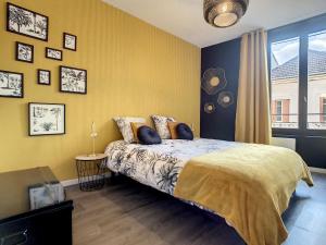a bedroom with a bed and a yellow wall at Le Temps d'une Pause in Bourgoin