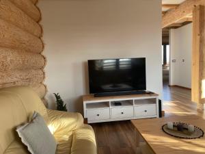 a living room with a television on a white entertainment center at Chata z Bala in Babiak