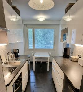 a kitchen with a sink and a table in it at 4 km to the Jyväskylä city center afoot, cute apartment with free parking in Jyväskylä