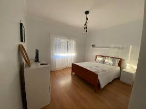 a bedroom with a bed and a dresser in it at Zulla House in Nazaré