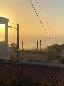 uma vista para o pôr-do-sol do oceano a partir de uma casa em Zulla House na Nazaré