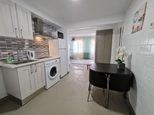 a kitchen with a table and a washing machine in it at Cómodo apartamento cerca del mar in Santa Pola