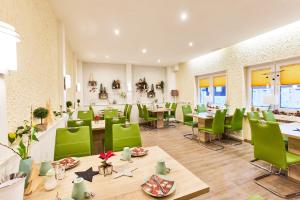 Hotel Berghof في باومهولدر: مطعم ذو كراسي خضراء وطاولات