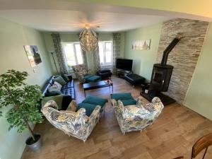 a living room with a couch and chairs and a wood stove at Atlantic Retreat Lodge in Kinvara