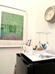 uma mesa com um relógio e uma imagem na parede em ByTheSea Guest House em Ayr