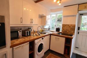 a kitchen with a sink and a washing machine at Hope Cottage, Great Longstone in Great Longstone