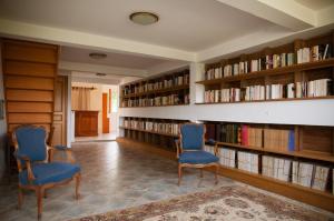 una biblioteca con 2 sillas azules y libros en Gîte des Grands Moulins de Baugé, en Baugé