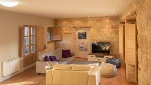 Una sala de estar con un sofá y un televisor. en Toro 2, 2º en la misma Plaza Mayor de Salamanca, en Salamanca