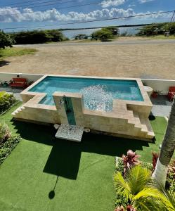 ein Schwimmbad in der Mitte eines Gartens in der Unterkunft Vistalmar Ocean Suites in Oranjestad