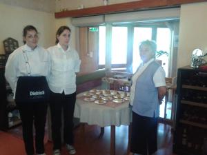 tres mujeres de pie junto a una mesa con pastelitos en Hotel Restaurant Home Des Hautes Vosges, en La Bresse