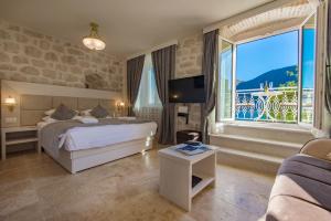 a hotel room with a bed and a large window at Conte Hotel & Restaurant in Perast +239 photos