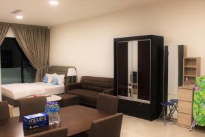 een hotelkamer met een bed en een bank bij Suasana Suite Cozy JB TOWN in Johor Bahru