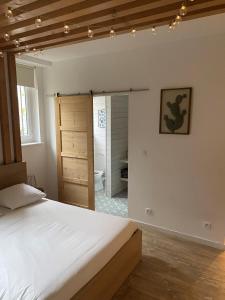 een slaapkamer met een bed en een badkamer bij Suite 24 Appart'hôtel-3 étoiles in Le Creusot